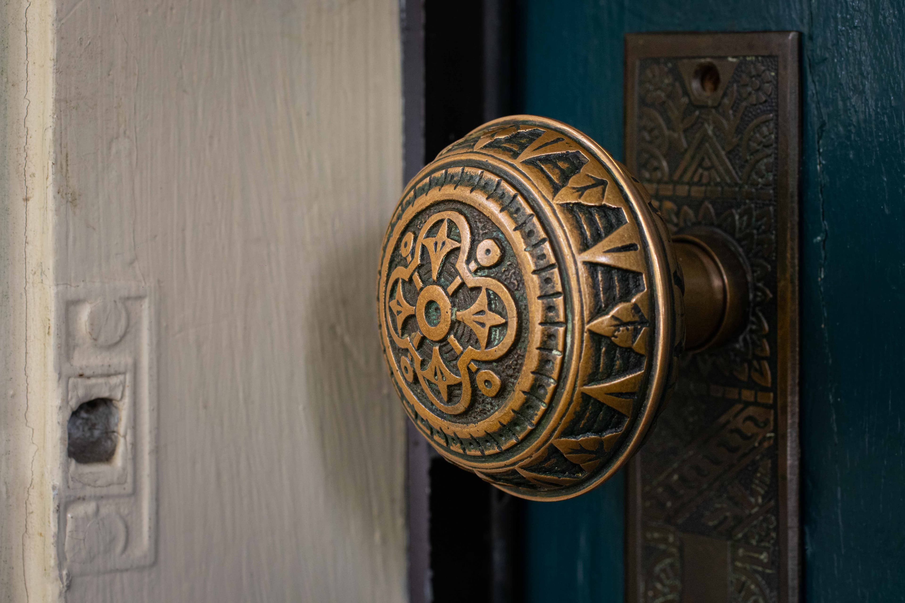 Close-up of an ornate bronze door knob.