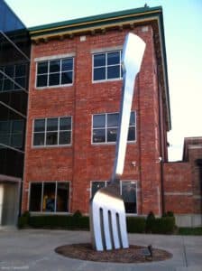 Giant metal fork sculpture in front of a brick building.