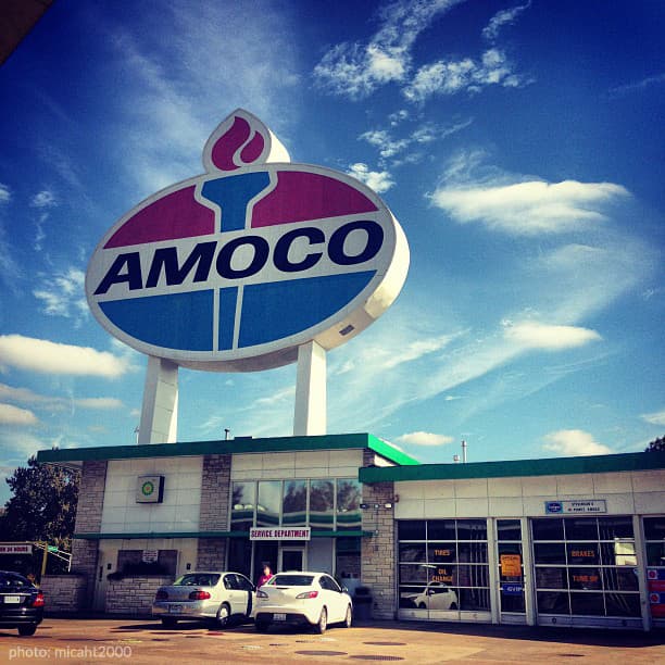 AMOCO gas station with a bright, retro sign against a blue sky.