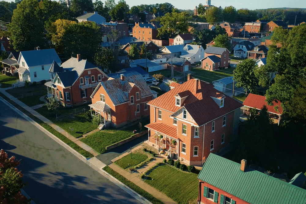 Aerial view of a suburban neighborhood featuring various homes and green spaces.